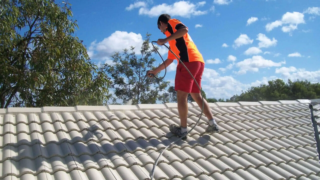 Painter spraying a concrete tile roof in Melbourne
