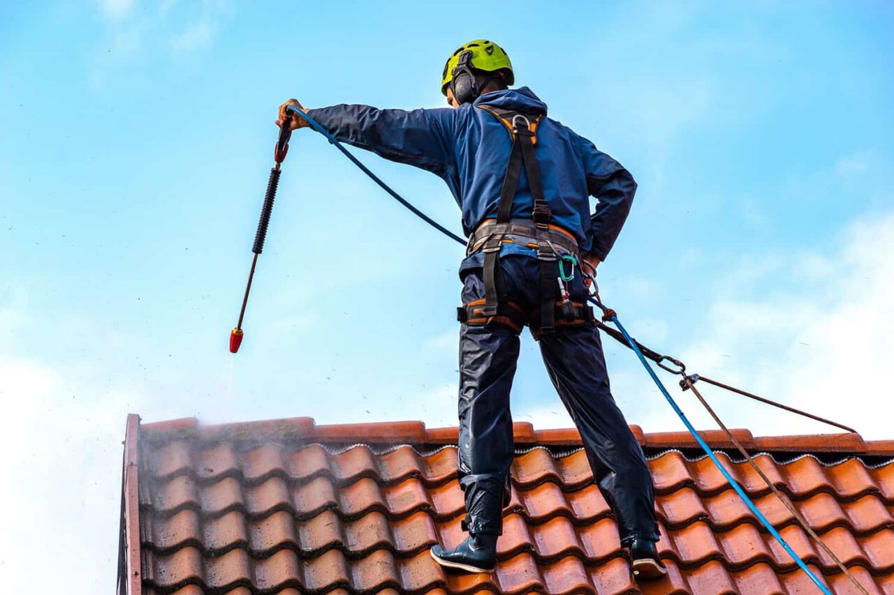Roofer wearing a safety harness while carrying out roofing restoration work